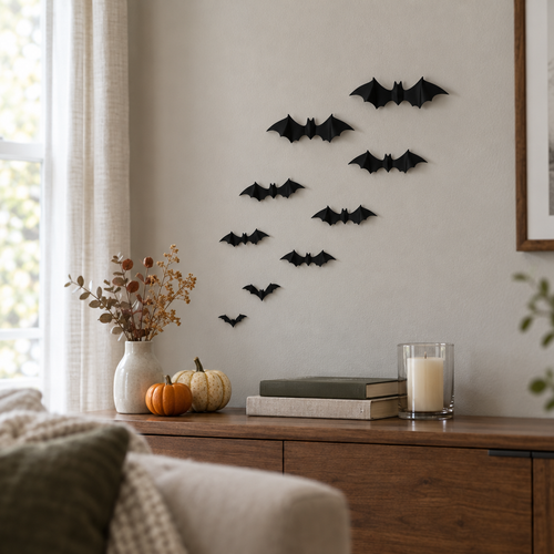 Black 3D bat stickers flying across a gray living room wall above pumpkins