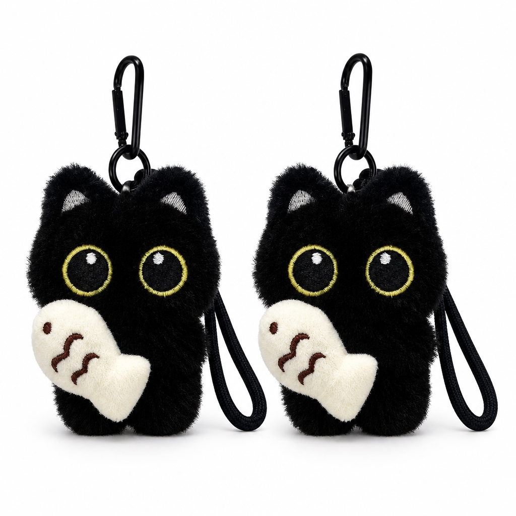 Two black cat plush keychains holding cream fish on a white background