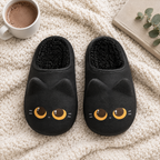 Black Cat Mule Slippers flat lay on a knit blanket with cocoa, a book and greenery