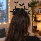 Adult wearing the black rose bat headband, seen from behind in a cozy room