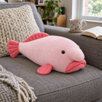 Pink blobfish plush lying on a gray sofa next to a knit cushion