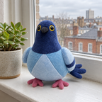 Blue pigeon plush standing on an apartment windowsill with city rooftops behind