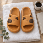 Caramel Capybara Slide Sandals flat lay on a white towel with coffee, a book and greenery