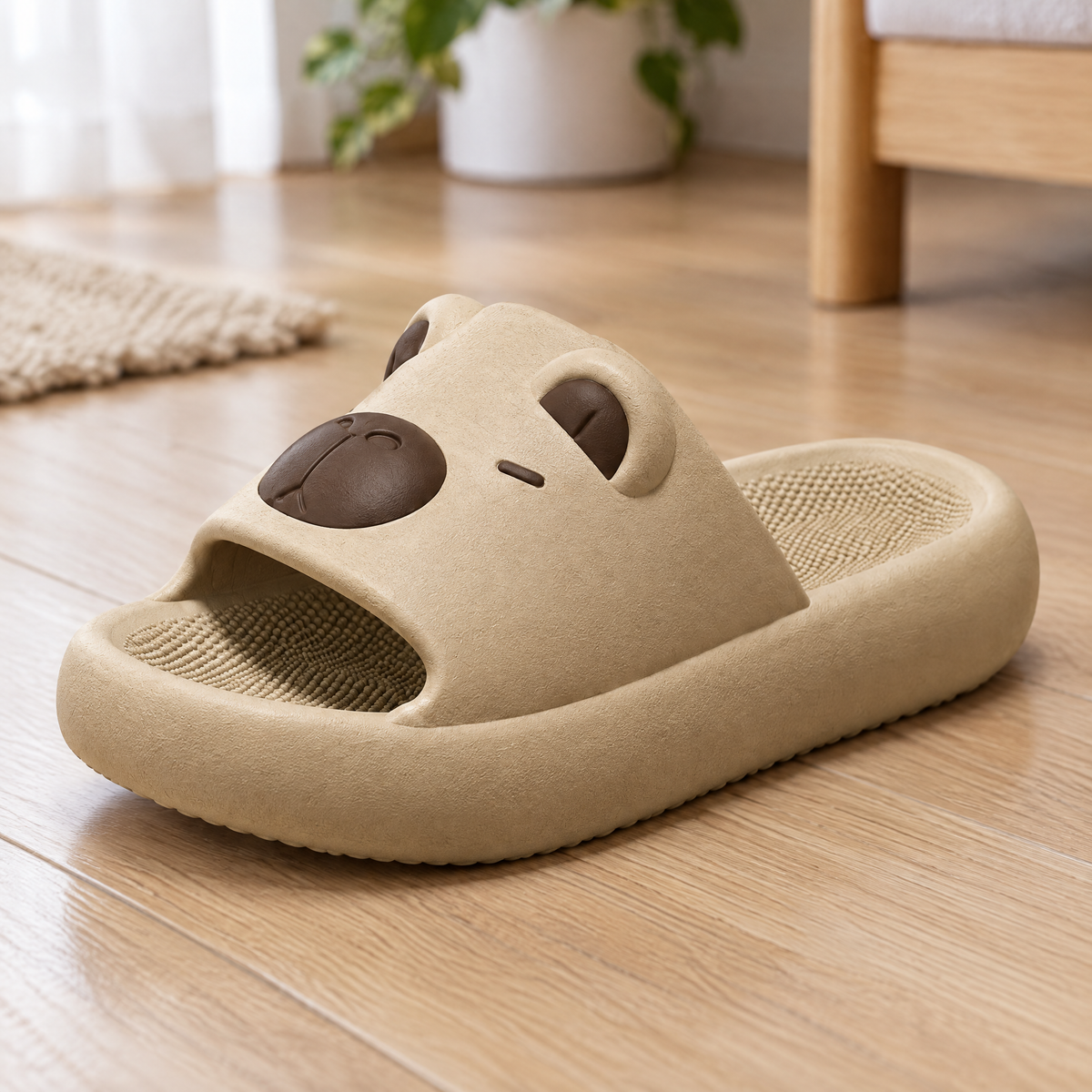 Close-up of a beige capybara slide sandal on a wooden floor, showing its thick cushioned sole