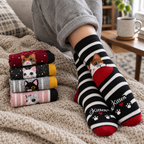 Adult feet in striped cat crew socks on a sofa next to the other four pairs