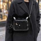 Adult wearing the black cat ear window bag with pins on a city street