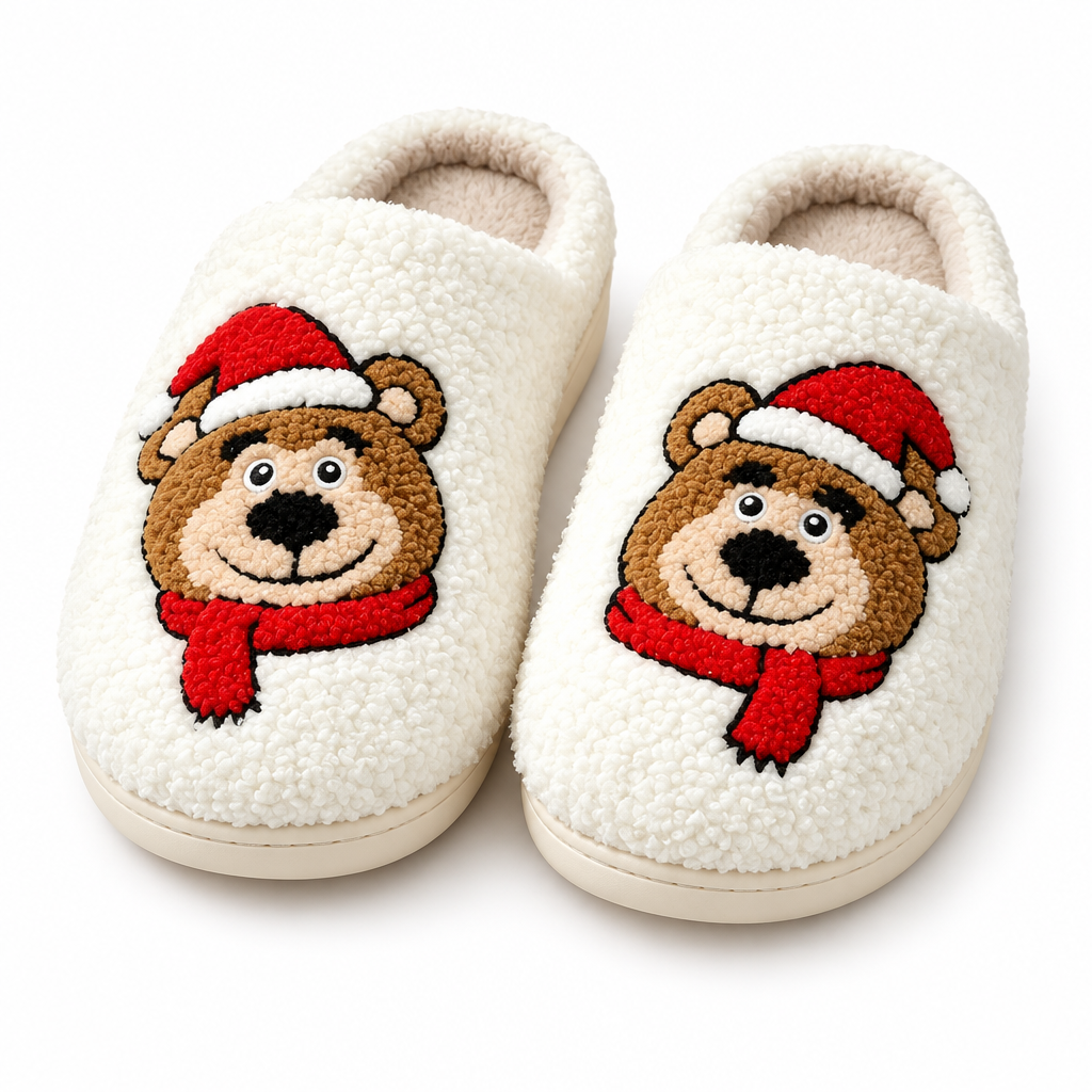 Cream fuzzy slippers with an embroidered brown bear in a Santa hat on a white background