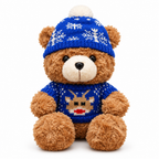 Brown teddy bear in a blue reindeer sweater and a snowflake beanie on a white background