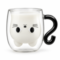 Clear double-wall cat mug filled with milk, with a black cat tail handle, on a white background