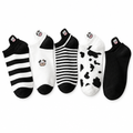 Five pairs of black and white cow ankle socks laid flat on a white background