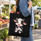 Adult carrying the black cow canvas tote bag at a farmers market