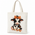Cream canvas tote bag with a spotted cartoon calf wearing an orange bow on a white background