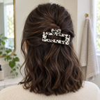 Cow print claw clip holding a half-up twist in brown hair