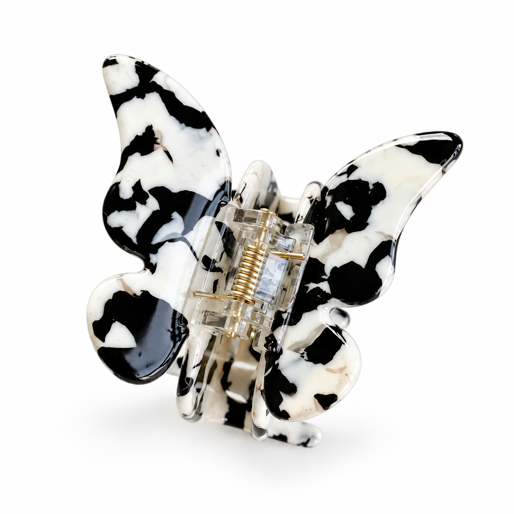 Butterfly-shaped cow print claw clip on a white background