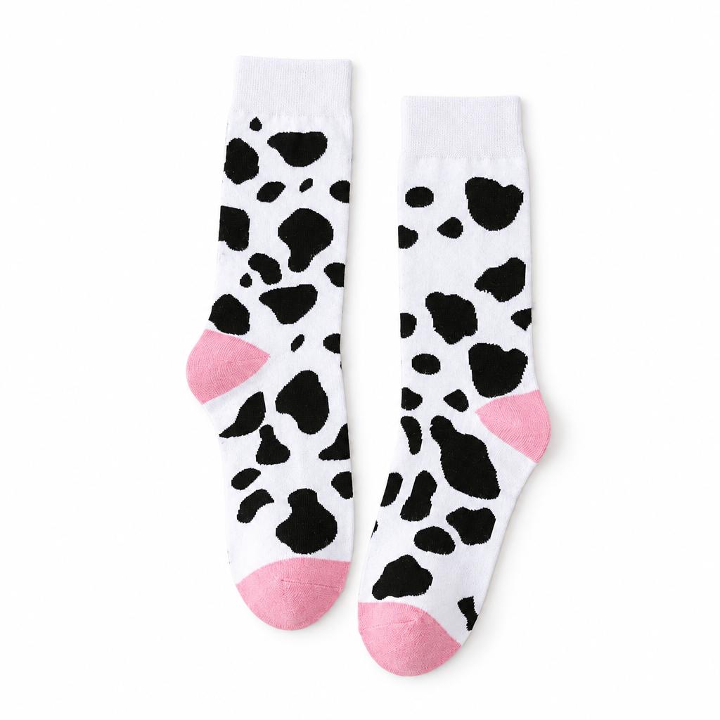 Pair of white cow print crew socks with pink heels and toes on a white background