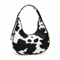 Black-and-white cow print half-moon shoulder bag on a white background