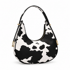 Black-and-white cow print half-moon shoulder bag on a white background
