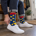 Adult in royal blue rubber duck crew socks putting on sneakers in an entryway