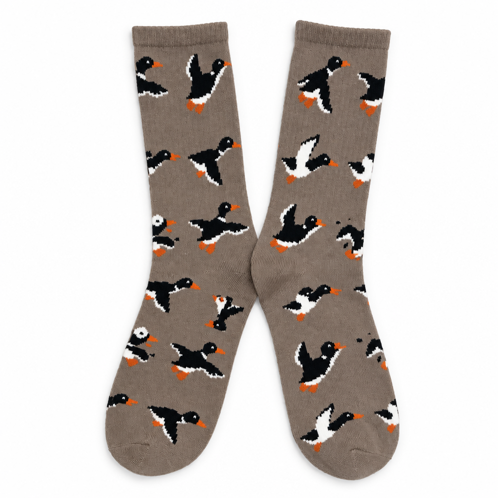 Taupe crew socks patterned with ducks in flight on a white background