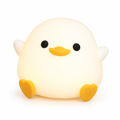 White silicone duck night light glowing softly on a white background