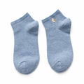 Light blue ankle socks with a small embroidered bird on a white background