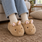 Adult feet in tan fluffy bunny slippers on a living room carpet
