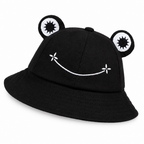 Black frog bucket hat with padded eyes and a white embroidered smile on a white background
