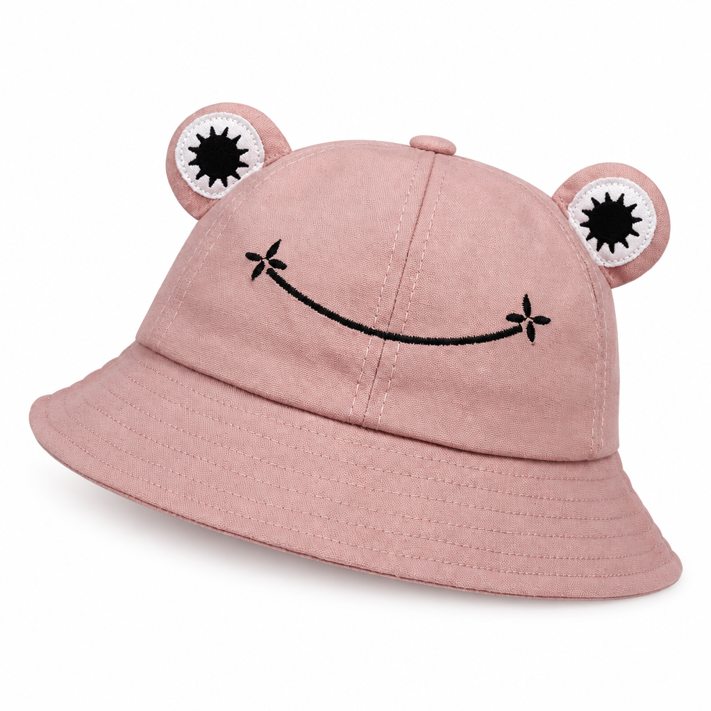 Dusty pink frog bucket hat with padded eyes and an embroidered smile on a white background