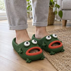 Adult feet wearing dark green frog cloud slides on a wooden floor