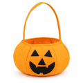 Orange pumpkin candy bucket with a black jack-o'-lantern face on a white background