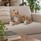 Spotted jaguar plush lying on a linen sofa cushion