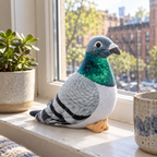 Lifelike pigeon plush standing on a sunny windowsill next to a succulent