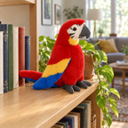 Red macaw parrot plush standing on a wooden bookshelf next to books and a plant