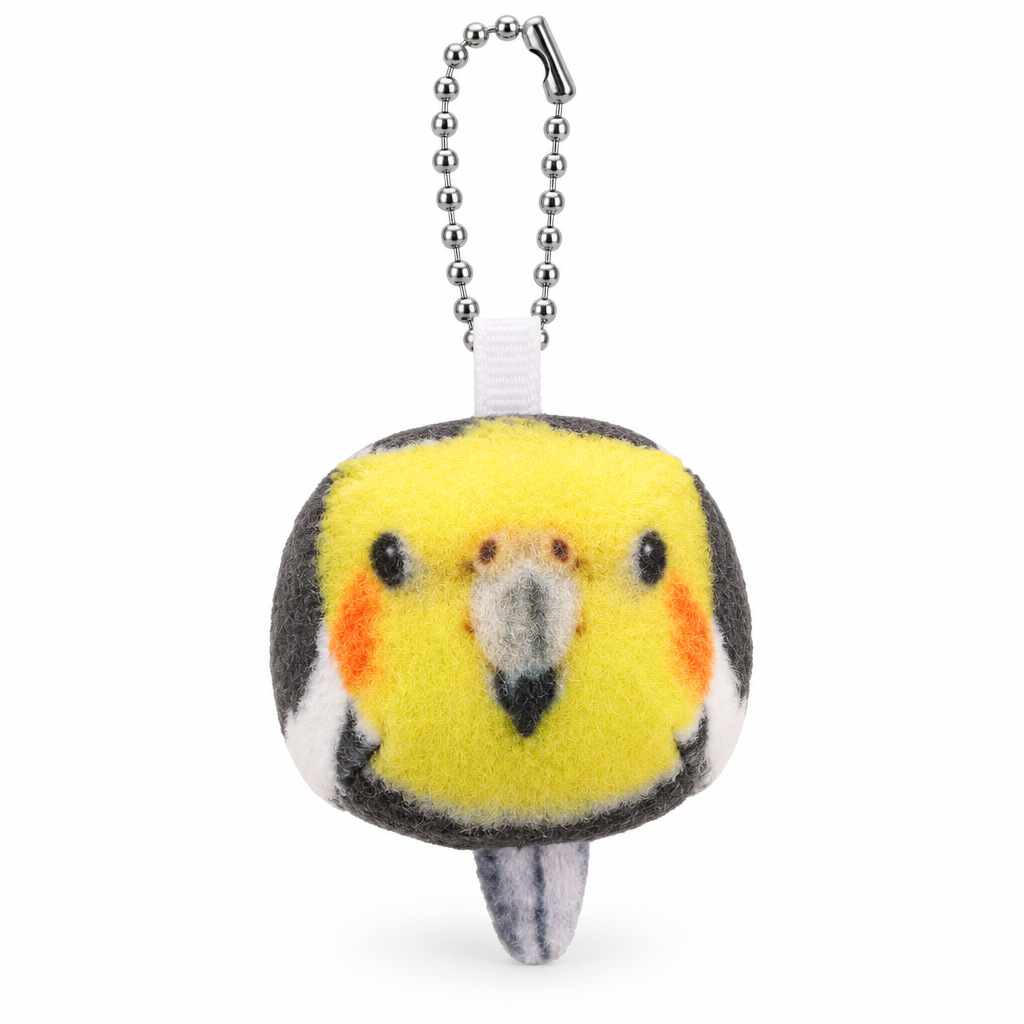 Yellow cockatiel plush bird head keychain with orange cheeks on a white background