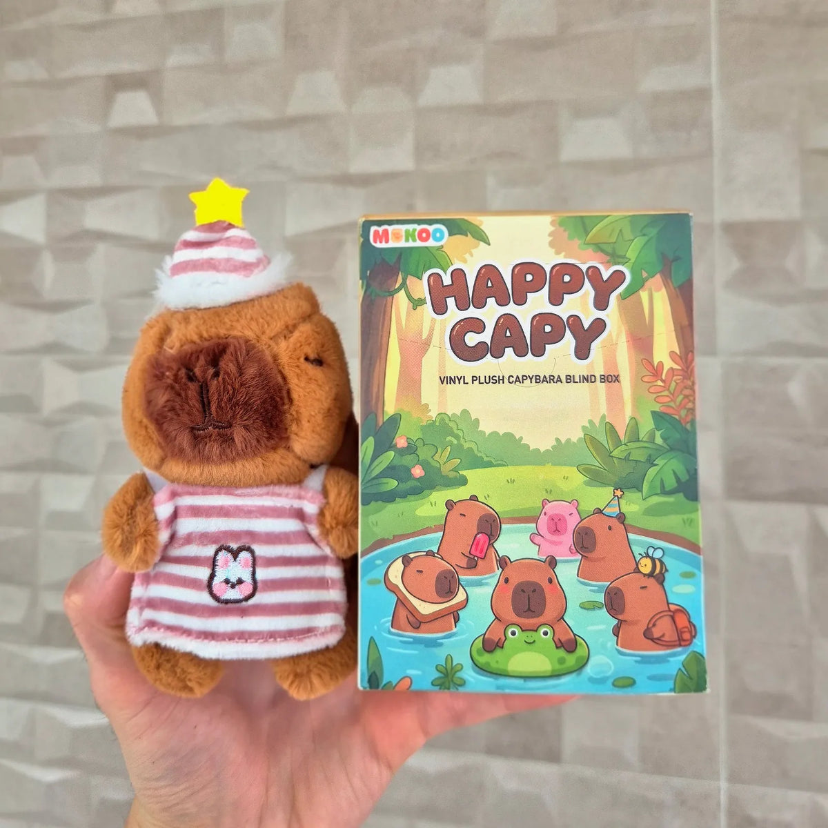 A real Bday plush held next to its Happy Capy blind box