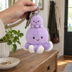 Lavender octopus keychain dangling from keys held in a hand