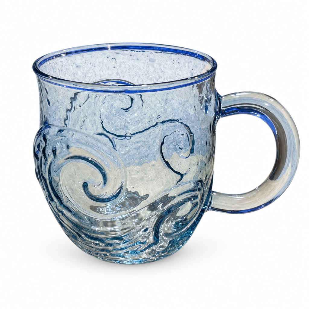 Clear blue glass mug with swirling waves and a blue rim on a white background