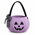 Lilac plush pumpkin bucket bag with a jack-o'-lantern face and striped bow on a white background