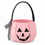 Pink plush pumpkin bucket bag with a jack-o'-lantern face and striped bow on a white background