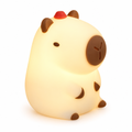Cream silicone capybara night light glowing on a white background