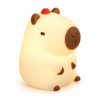 Cream silicone capybara night light glowing on a white background