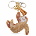 Rhinestone sloth keychain with a keyring, gold bead and tan tassel on a white background