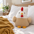 Round hen plush sitting on a made bed against white pillows