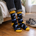 Adult feet in black shark crew socks on a wooden bedroom floor