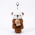 Brown sea otter plush keychain hugging a fish on a white background