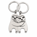 Two silver sloth keychains fitting together into a hug on a white background