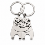 Two silver sloth keychains fitting together into a hug on a white background