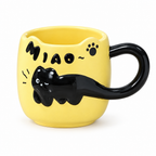 Butter yellow ceramic mug with a black cat tail handle on a white background