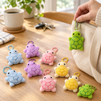 Pastel plush turtle keychains on a table, one being clipped to a tote bag zipper