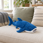 Blue spotted whale shark plush lying on a cream sofa